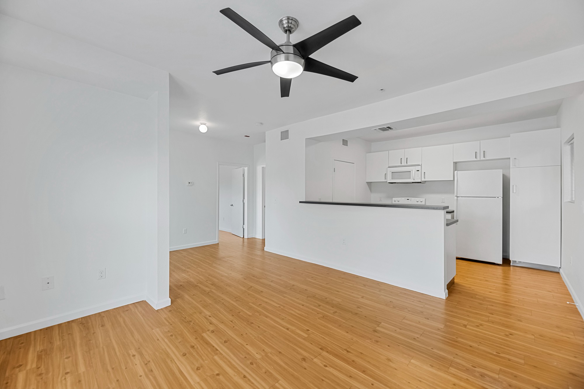 Green Spring Apartments near TXST unfurnished living room, common area, and kitchen